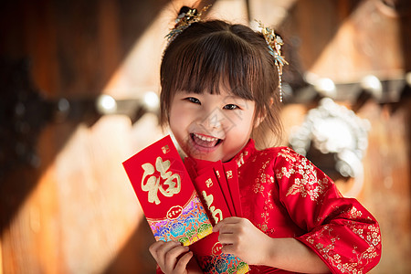 微笑的表情可爱的小女孩拿着红包背景