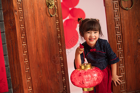 传统节日元宵节漂亮的小女孩手提红灯笼庆祝新年背景