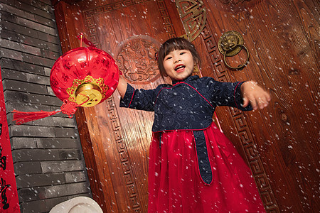 雪中的小女孩手提红灯笼庆祝新年图片
