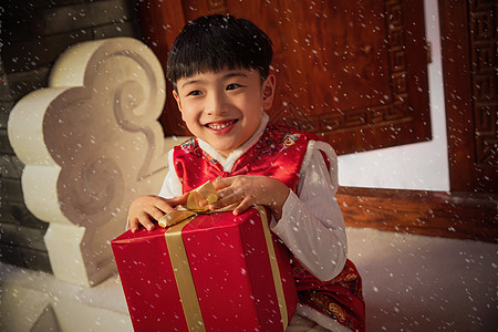 可爱的小男孩抱着礼品盒图片