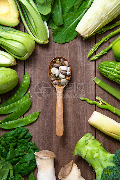 绿色果蔬和木匙上的多色药品图片