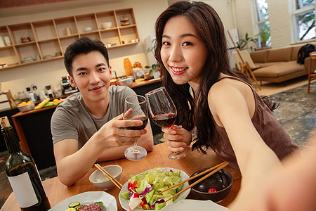 红酒庆祝年轻夫妇在家用餐背景