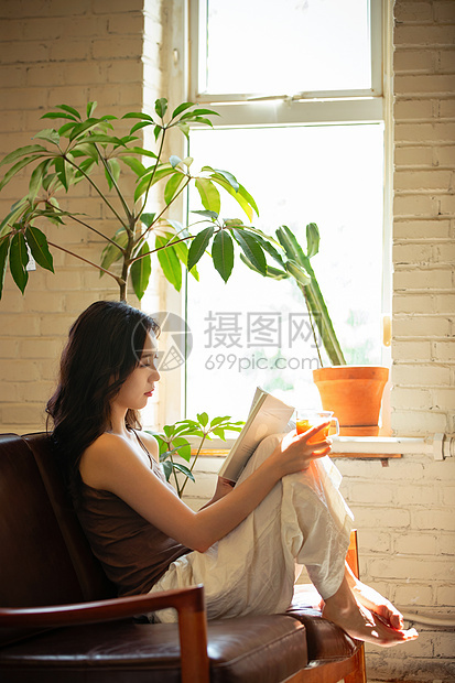 年轻女人在家喝茶看书图片