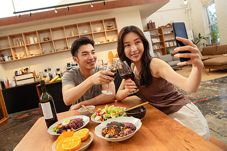 红酒庆祝年轻夫妇在家用餐背景