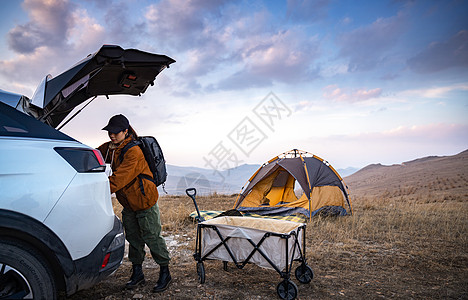新疆风光自驾的年轻女人准备露营背景