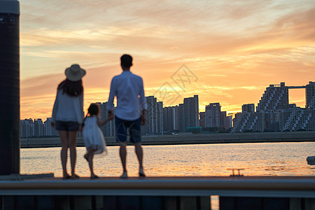 夕阳海滩一家三口在海边玩耍背景