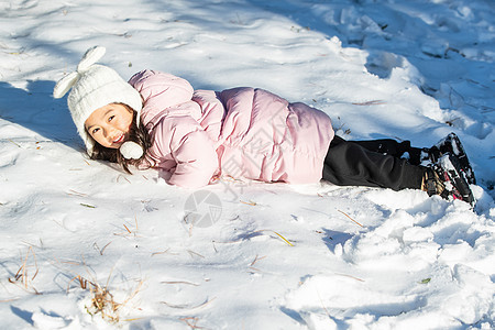 快乐的小女孩在雪地里玩耍图片