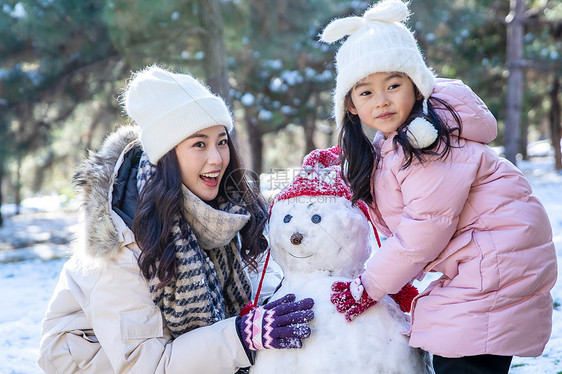 快乐的母女推雪人图片