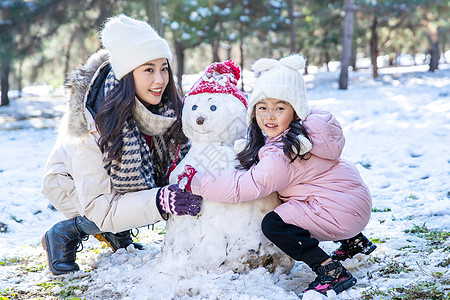 快乐的母女推雪人图片