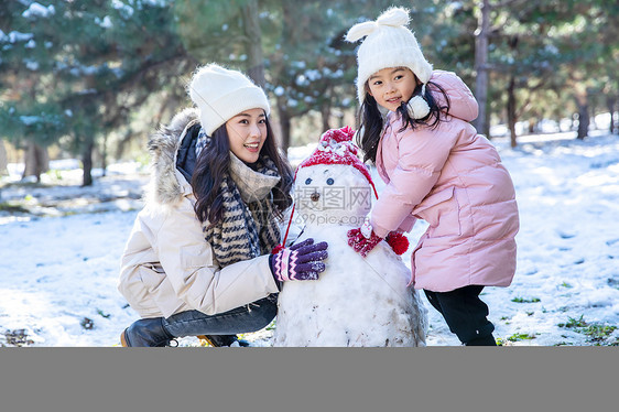 快乐的母女推雪人图片