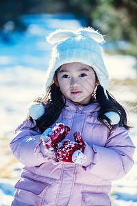 快乐的小女孩在雪地里玩耍图片