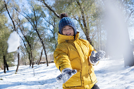 快乐的小男孩在雪地里玩耍图片