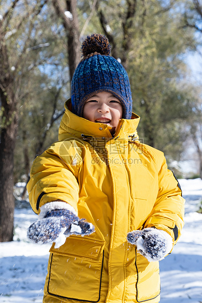 快乐的小男孩在雪地里玩耍图片