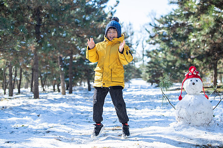 快乐的小男孩在雪地里玩耍图片