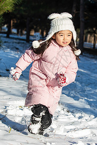 快乐的小女孩在雪地里玩耍图片