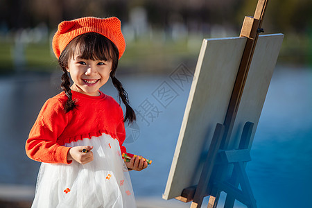 东方儿童可爱的小女孩在户外画画背景