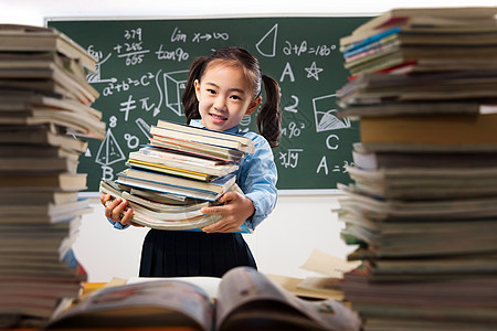 搬着沉重课本的小学女生图片