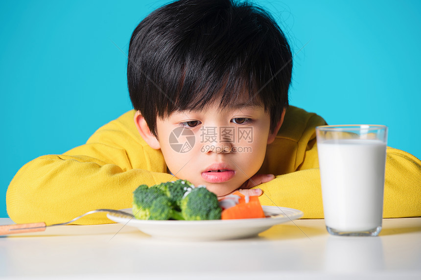 盯着蔬菜发愁的小男孩图片