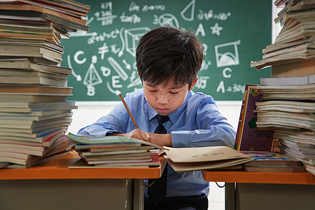 拿着铅笔的男孩课堂上的小学生写作业背景