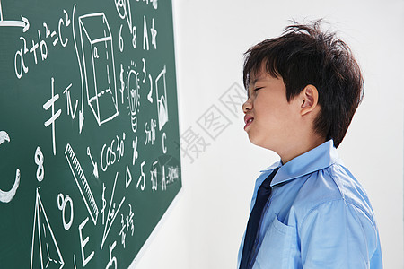 小男孩侧面小学男生被数学题难住背景