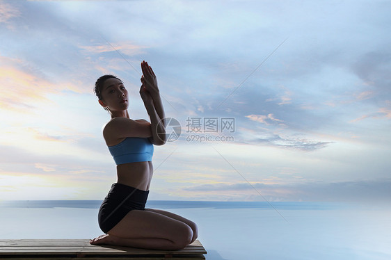 年轻女人在水面上练习瑜伽图片