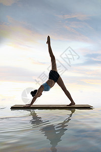 年轻女人在水面上练习瑜伽图片
