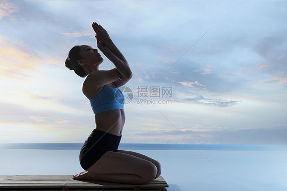 年轻女人在水面上练习瑜伽图片