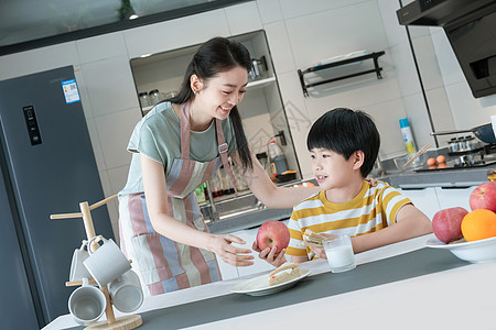 男孩做早餐年轻妈妈给孩子做早餐背景