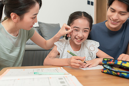 年轻父母辅导女儿做作业图片