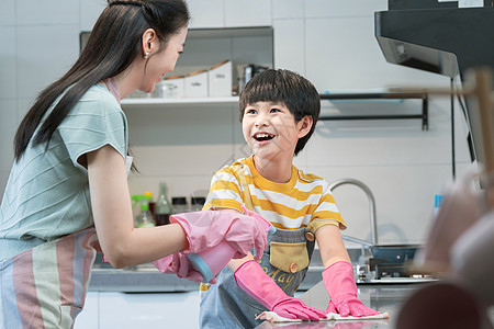 年轻妈妈指导儿子在厨房打扫卫生图片