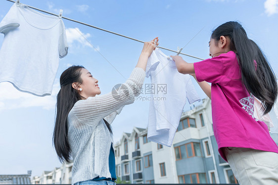 年轻妈妈和女儿晾衣服图片