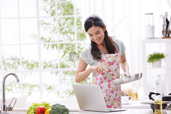 年轻女人在厨房做饭图片