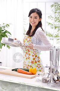 胡萝卜粥年轻女人在厨房做饭背景