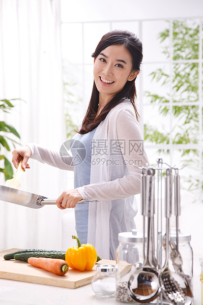 年轻女人在厨房做饭图片