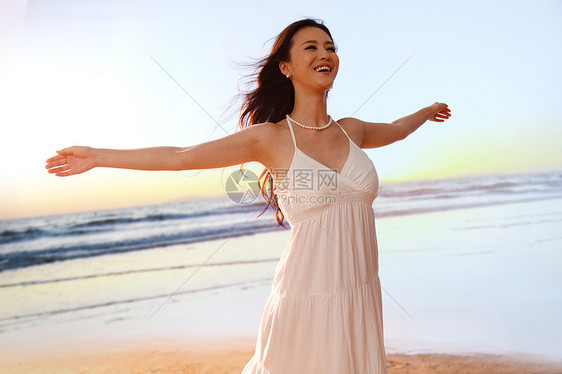 快乐的年轻女在海边跳跃图片