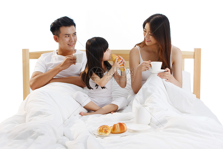 一家三口在卧室的床上吃早餐图片