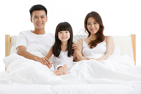 幸福的一家三口在卧室的床上图片
