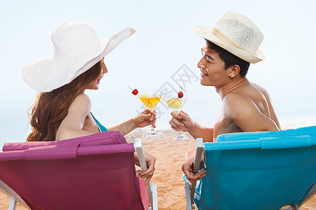 沙滩上喝饮料的浪漫情侣图片