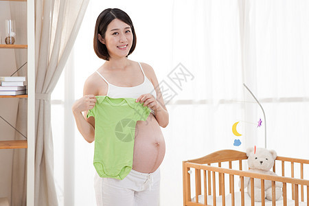 孕妇拿着婴儿衣服图片