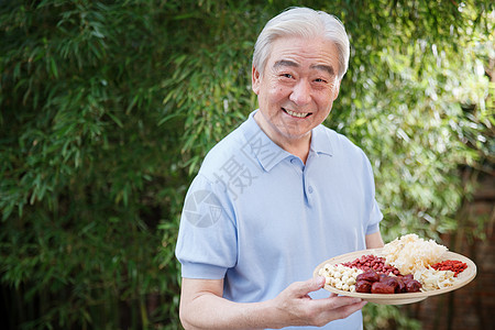 一个老年男人拿着干果图片