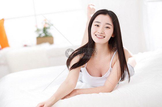 青年女人在卧室的床上图片