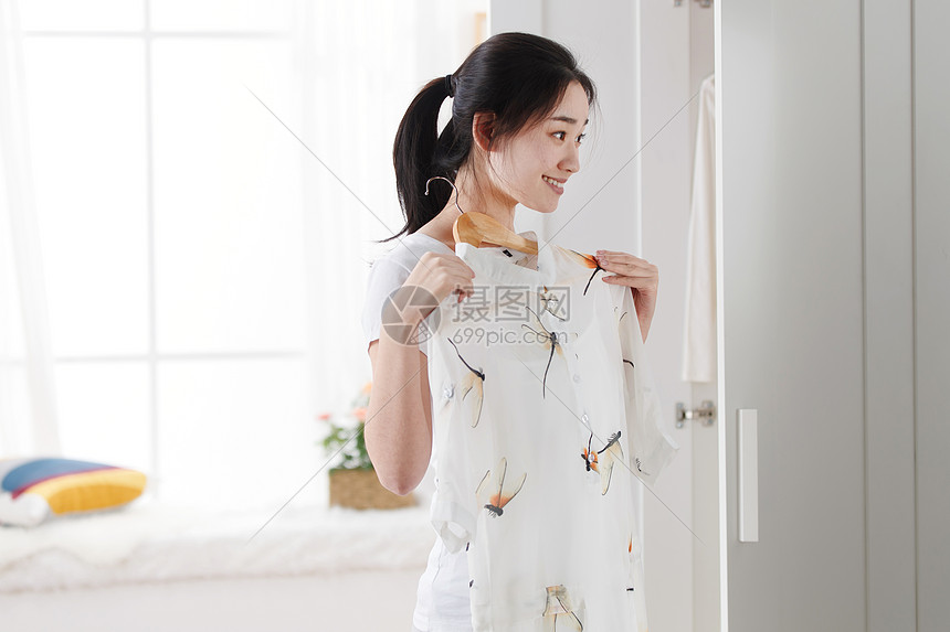 青年女人在卧室试衣服图片