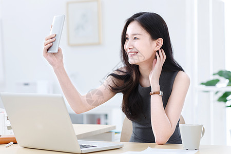 商务女人使用手机自拍图片