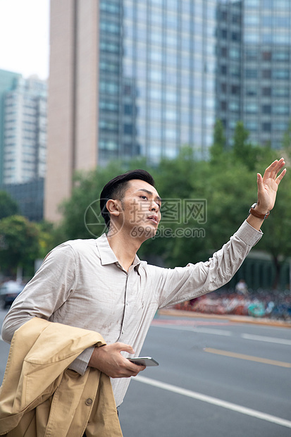 商务男士在商业区拦出租车图片