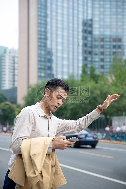 商务男士在商业区拦出租车图片