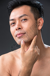 用手指触摸胡茬的中年男人图片