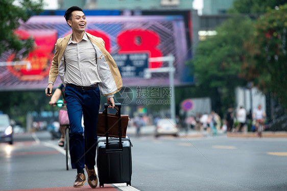 马路上拉着行李追赶汽车的商务男子图片