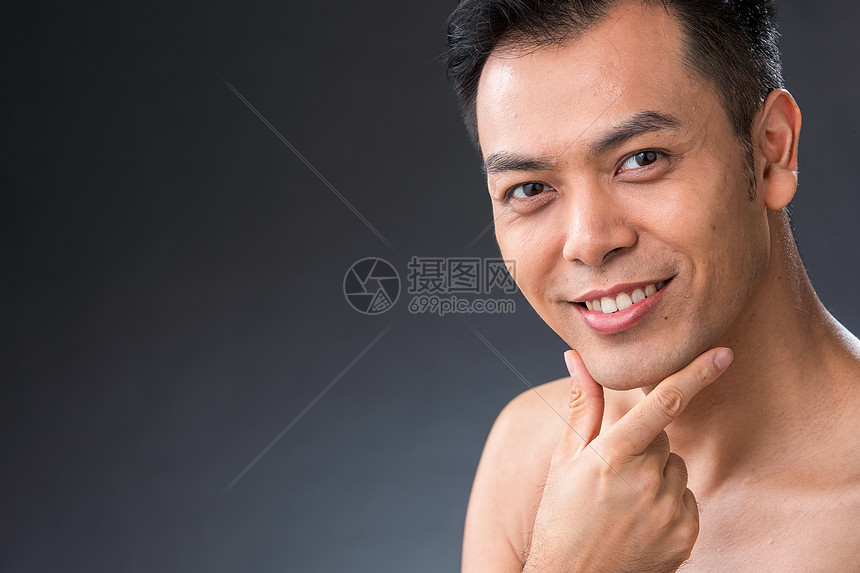 手指触摸下巴的快乐中年男人图片