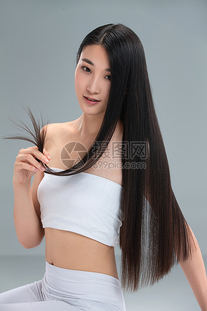 青年女人展示亮丽丝缎般的头发图片
