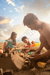 年轻父亲带着孩子们在沙滩玩耍高清图片